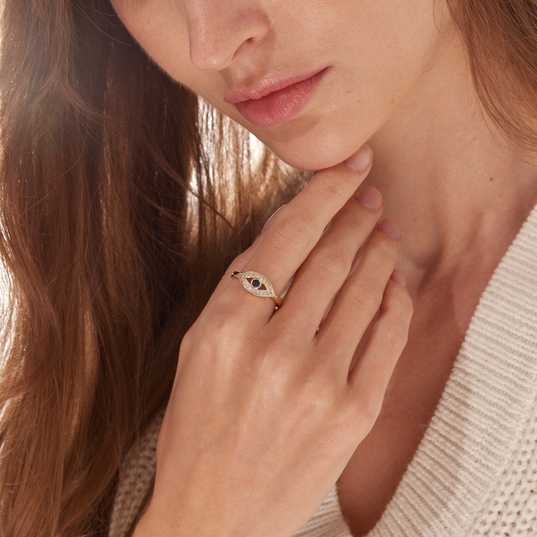 A model wearing a blue evil eye adjustable ring