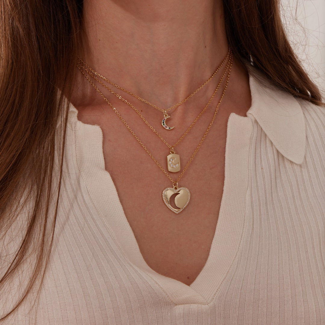 Jeweled Moon Gold Tag Necklace worn by a model together with other necklaces