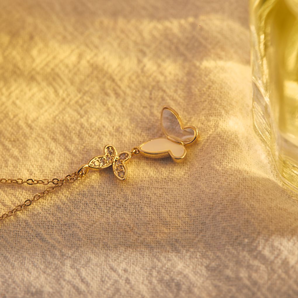 Duo Butterfly Gold Chain Necklace placed on top of a white piece of cloth